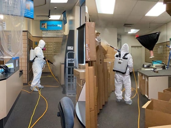 Two men in white suits are cleaning a room.