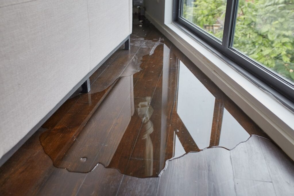 Water leaking and flooded on wood parquet floor.
