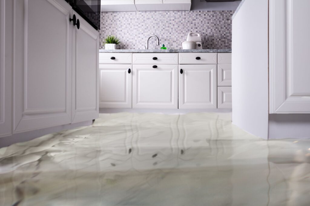 A kitchen with white cabinets and marble floors.