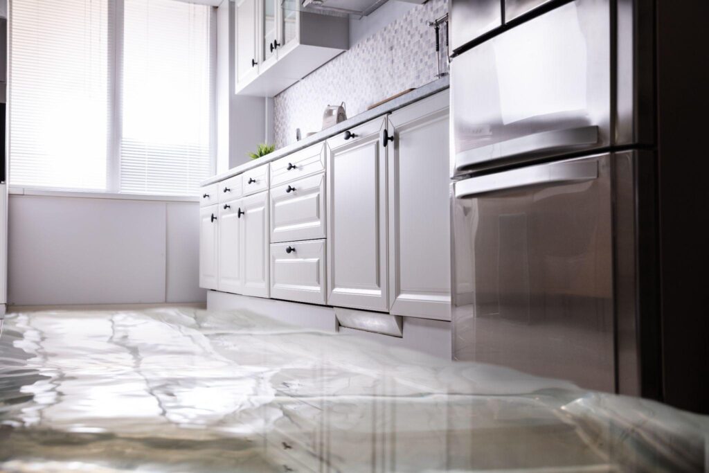 A kitchen with a floor that has been flooded.