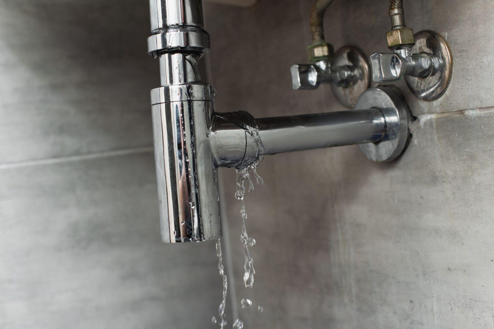 A faucet that is leaking water from the wall.