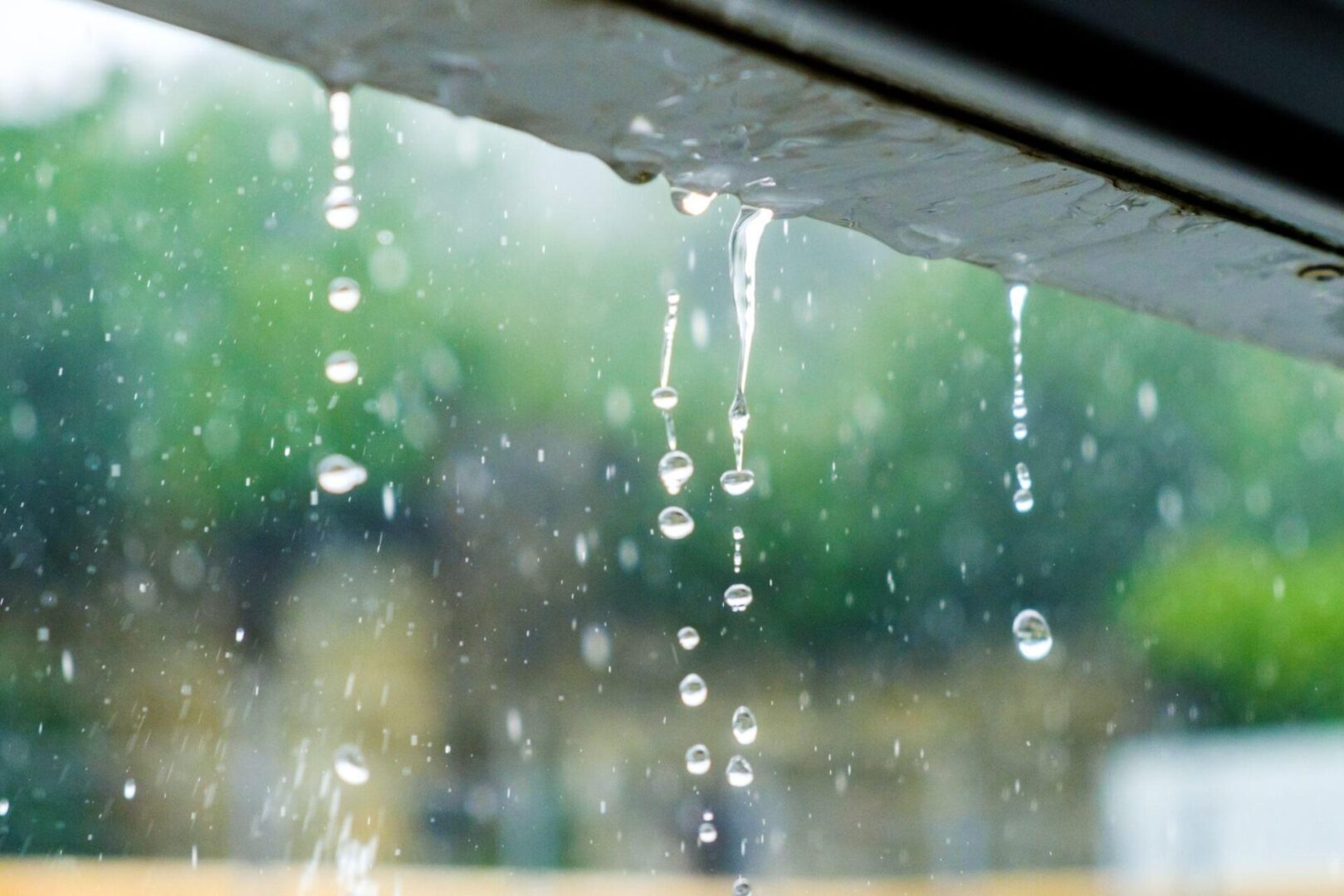 A window with water droplets hanging from it.