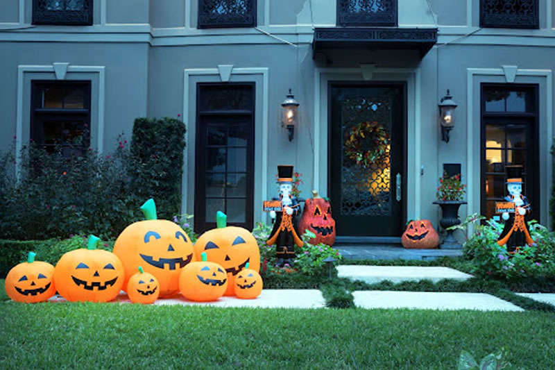 A bunch of pumpkins are sitting in front of the house