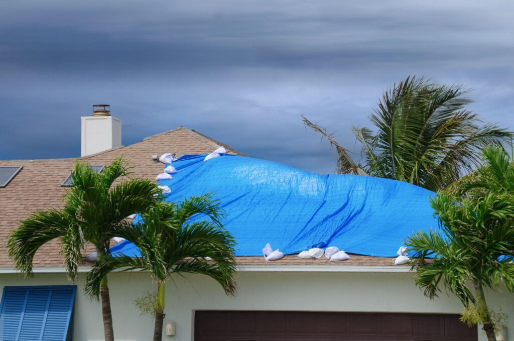 A blue tarp covering the roof of a house.