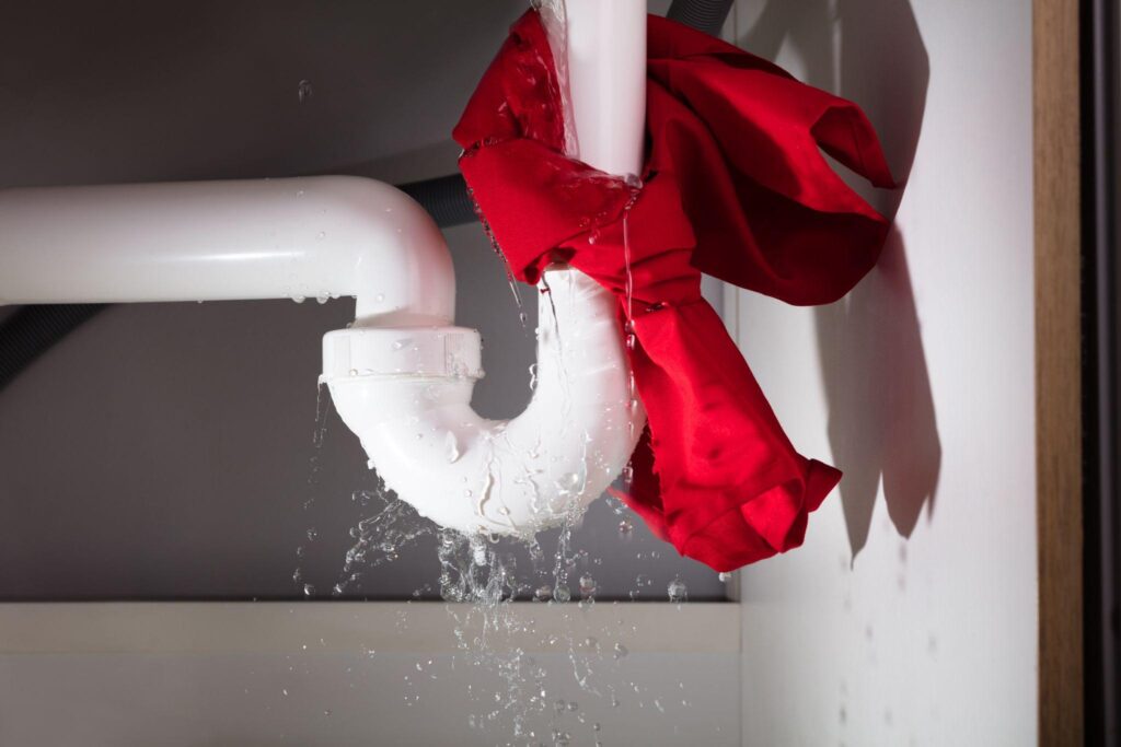 Red napkin tied under the leakage sink pipe